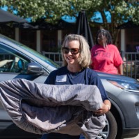 GVSU Alumna smiles while carries in luggage